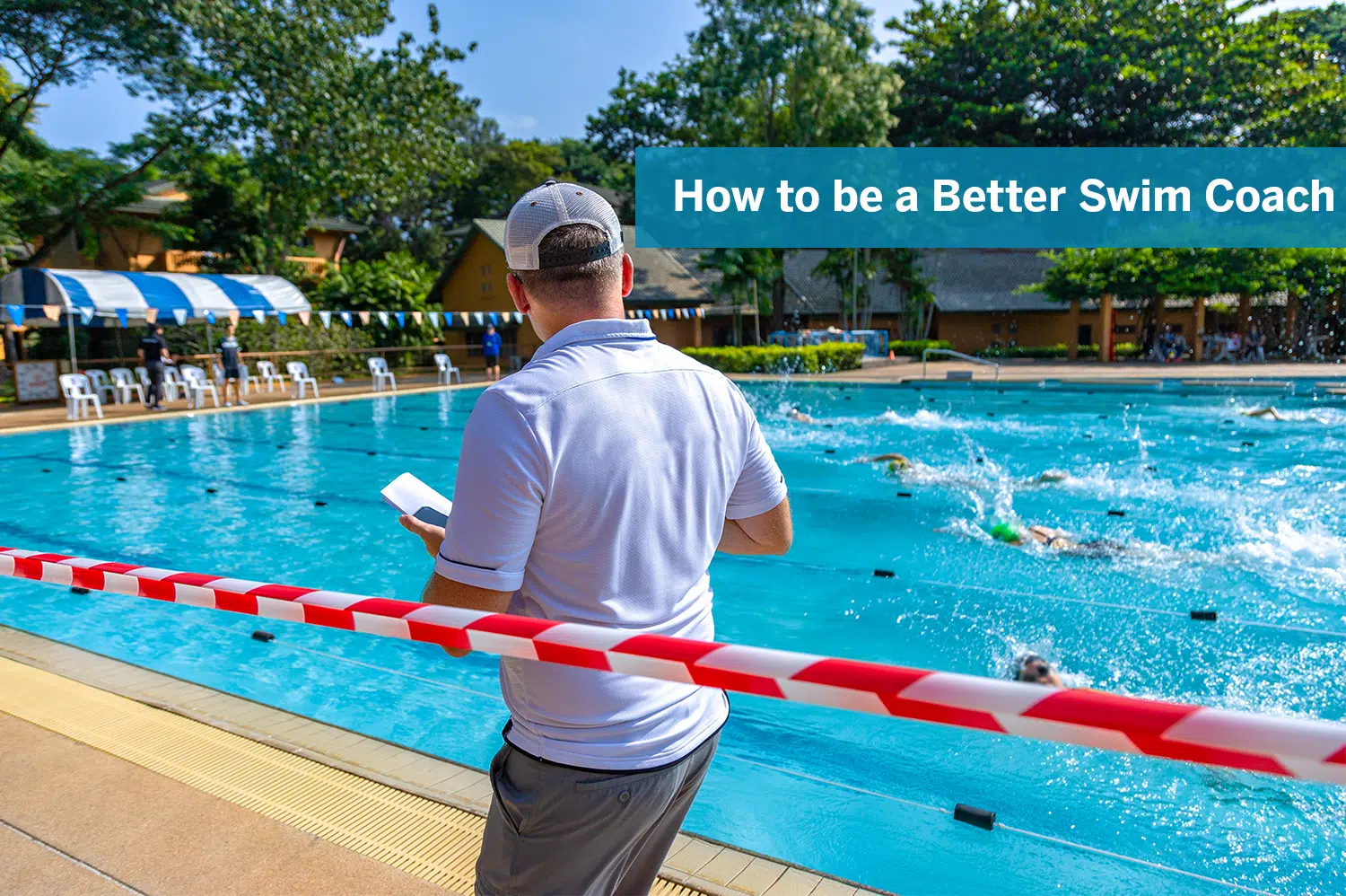 A swim coach watching his swimmers race in an outdoor pool.